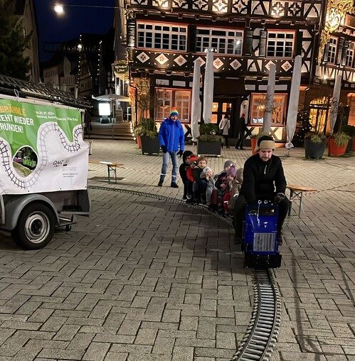 Mobile 5-Zoll-Bahn mit blauer Lok und roten Waggons bei einer Veranstaltung
